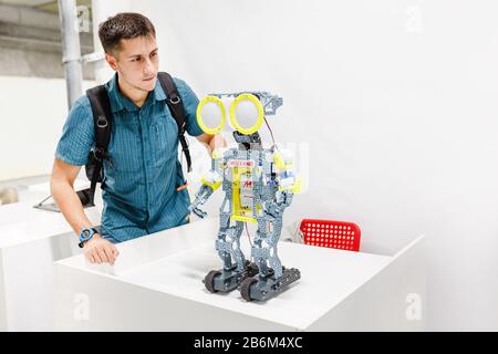 21 AOÛT 2017, ULTRA MALL, UFA, RUSSIE : un visiteur d'une exposition de robots regarde une machine automatisée Banque D'Images