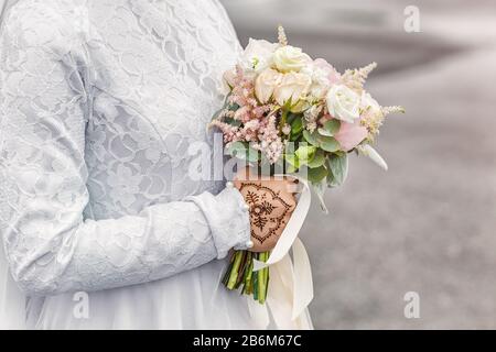 Bouquet de mariage de nikah pastel dans les mains de la mariée avec mehendi tattoo gros plan Banque D'Images