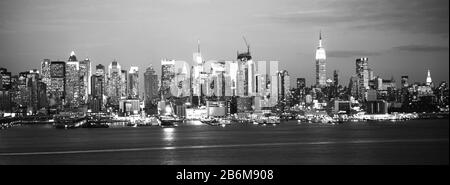 Des gratte-ciel illuminés la nuit dans une ville, Manhattan, New York City, New York State, États-Unis Banque D'Images