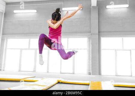 danseuse moderne hip-hop sautant et faisant dab dans la salle de fitness trampoline Banque D'Images