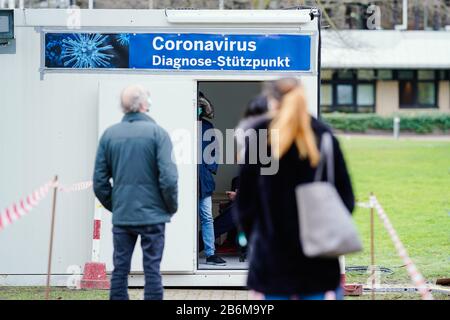 Mannheim, Allemagne. 11 mars 2020. Les gens se tiennent devant des conteneurs spécialement mis en place pour l'essai sur le nouveau coronavirus sur le terrain de l'hôpital universitaire. Une bannière portant l'inscription « Coronavirus Diagnostic base » est jointe à l'entrée des conteneurs. En raison de l'épidémie de coronavirus, l'hôpital universitaire a mis en place une base de diagnostic du coronavirus à partir d'aujourd'hui. Crédit: Uwe Anspach/Dpa/Alay Live News Banque D'Images