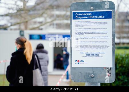 11 mars 2020, Bade-Wuerttemberg, Mannheim: Les gens se tiennent sur le terrain de l'hôpital universitaire devant des conteneurs mis en place spécialement pour l'essai sur le nouveau coronavirus et derrière un panneau disant "Coronavirus Diagnostic base". En raison de l'épidémie de coronavirus, l'hôpital universitaire a mis en place une base de diagnostic du coronavirus à partir d'aujourd'hui. Photo: Uwe Anspach/Dpa Banque D'Images