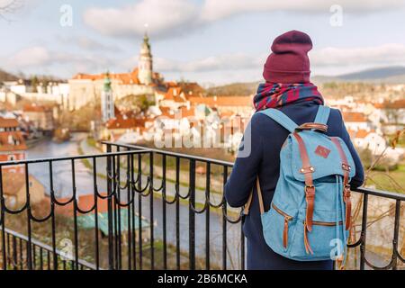 Femme touriste dans un manteau avec un sac à dos voyage dans les vieilles rues de Cesky Krumlov ville, concept de vacances en Europe Banque D'Images