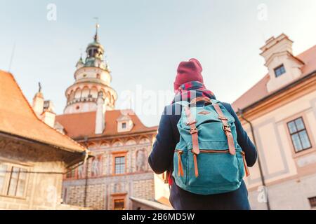 Femme touriste dans un manteau avec un sac à dos voyage dans les vieilles rues de Cesky Krumlov ville, concept de vacances en Europe Banque D'Images