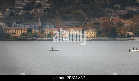 Côme près de Milan, Italie - 4 novembre 2017 : atterrissage en hydravion sur le lac de Côme avec de petits bateaux de pêcheurs en automne Banque D'Images