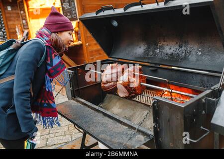 La femme regarde la viande de porc rôtie sur un feu ouvert dans le gril Banque D'Images