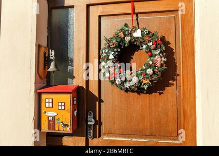 Décembre 2017, KARLSTEJN, RÉPUBLIQUE TCHÈQUE : couronne de Noël faite à la main sur une porte en bois avec boîte de poste inhabituelle Banque D'Images