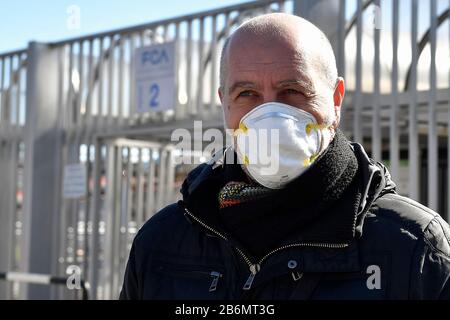 Turin, Italie. 11 mars 2020. Turin, ITALIE - 11 mars 2020: Un employé de la FCA portant un masque respiratoire quitte l'usine automobile Fiat Mirafiori. La FCA a temporairement fermé quatre usines (Pomigliano, Melfi, Sevel di Atessa et Cassino) à travers l'Italie pour empêcher la propagation du coronavirus COVID-19. (Photo De Nicolò Campo/Sipa Usa) Crédit: Sipa Usa/Alay Live News Banque D'Images