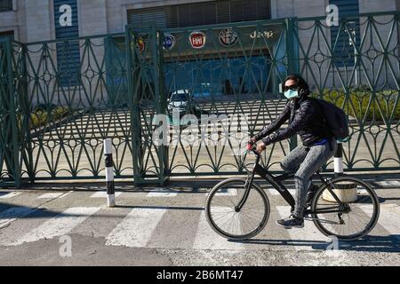 Turin, Italie. 11 mars 2020. Turin, ITALIE - 11 mars 2020: Une femme portant un masque respiratoire passe devant l'usine automobile Fiat Mirafiori aujourd'hui partie de FCA (Fiat Chrysler automobiles). La FCA a temporairement fermé quatre usines (Pomigliano, Melfi, Sevel di Atessa et Cassino) à travers l'Italie pour empêcher la propagation du coronavirus COVID-19. (Photo De Nicolò Campo/Sipa Usa) Crédit: Sipa Usa/Alay Live News Banque D'Images