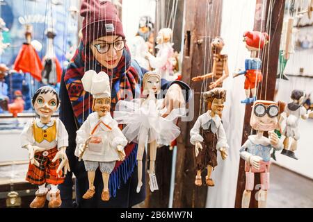 Femme client regardant les marionnettes traditionnelles en bois à la boutique Banque D'Images