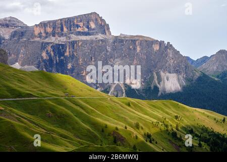 Groupe de montagne de Sella dans les Dolomites, Italie, au coucher du soleil, avec des rayons de lumière sur les couches vertes d'herbe. Banque D'Images