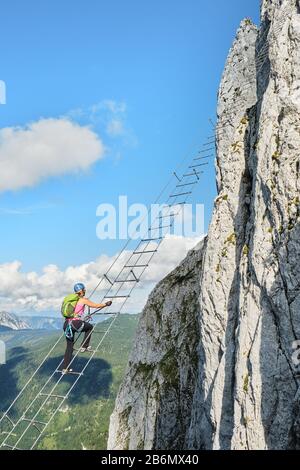 Femme sur via ferrata Intersport Klettersteig dans les montagnes de Donnerkogel, Autriche. Banque D'Images