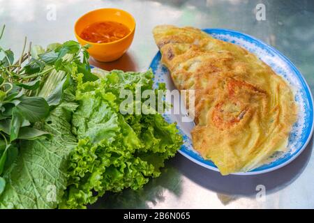 Crêpes vietnamiennes de crevettes - Banh Xeo servi avec des légumes et de la sauce Banque D'Images