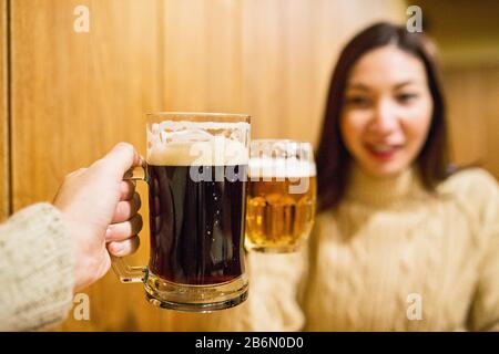 Deux tasses à bière claires et sombres sont inclinées dans la taverne tchèque Banque D'Images