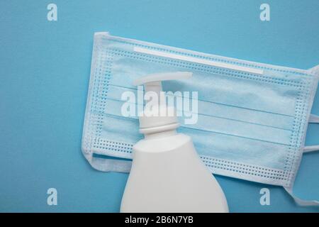 Masque médical de protection et savon anti-bactérien pour les mains sur un fond bleu Banque D'Images