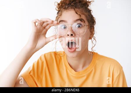 Plus de détails. Portrait choqué étonnés impressionnée séduisante fille à tête rouge largue les yeux s'étonnent découvrir amusant rumeur debout Banque D'Images