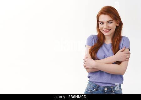 Obtenir des enfants, fille veulent cuddle ou acheter quelque chose de chaud, décidez magasin en ligne. Jolie femme souriante et souriante dans un t-shirt, embrassant son propre corps Banque D'Images