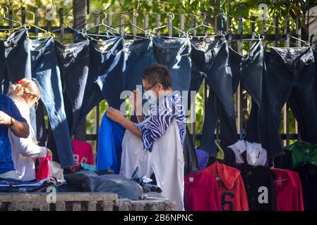 San Salvador, El Salvador. 11 mars 2020. Une femme portant un masque de visage des magasins de vêtements dans un magasin de rue.Après le Honduras (UN pays voisin) a confirmé 2 cas de virus Corona, les salvadoriens s'attendent à une arrivée prochaine de la pandémie.El Salvador n'a pas encore confirmé les cas de COVID-19. Crédit: Camilo Freedman/Zuma Wire/Alay Live News Banque D'Images