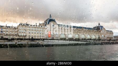 Vue sur le bâtiment du Musée d'Orsay depuis une fenêtre pluvieuse du bateau de croisière sur la Seine, Paris, France Banque D'Images