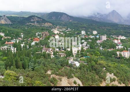 Un grand nuage noir vient des montagnes au village de villégiature de faible hauteur Simeiz. Crimée, Yalta Banque D'Images