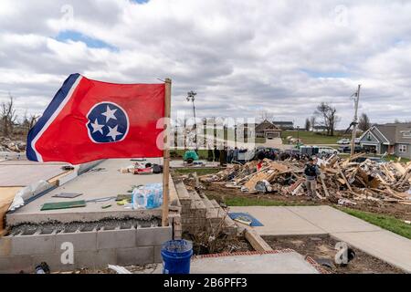 Le drapeau de l'État du Tennessee vole au-dessus de maisons détruites à la suite d'une tornade massive le 6 mars 2020 à Cookeville, dans le Tennessee. Le président américain Donald Trump s'est rendu à Nashville et dans les environs pour étudier les tornades qui ont tué plus de 24 personnes. Banque D'Images