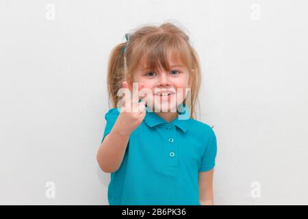 Une jeune fille de 4 ans qui colle 2 doigts vers le haut. Banque D'Images