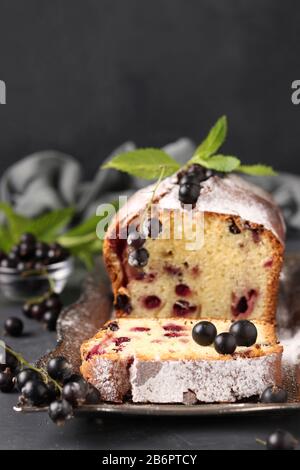 Cupcake avec cassis noir situé sur un plateau métallique sur fond sombre, format vertical Banque D'Images