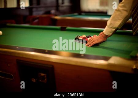 Vue sur quelques balles disposées par un homme sur une table de billard. Banque D'Images