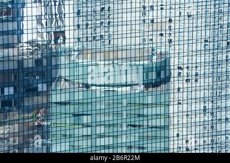 Verre miroir d'un gratte-ciel commercial reflétant un autre bâtiment avec hélipad à Tokyo, Japon. Construction symétrique avec verre et acier. Banque D'Images