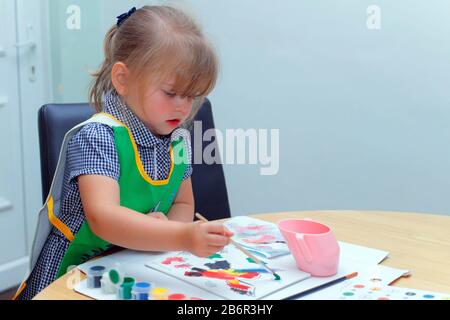 Une petite fille à l'aide d'un pinceau pour peindre une photo Banque D'Images