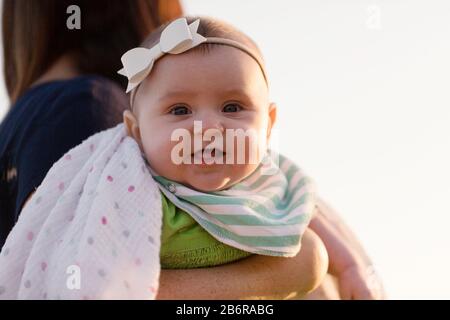 Une mère et son bébé s'arrêtent et sentent les fleurs. Banque D'Images