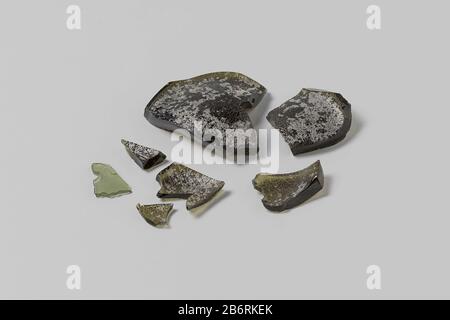 De zeven fragmentien maken deel uit van de bodems van wijnflessen, blijkens de dikkte van het groene glas en de opstaande wanden. Le scherven hebben en glade en een ruwe kant met aanslag en irizeren. Fabricant : glasblazer: Datant: 1700 - 1735 matériau: Groen glas Techniek: Blazen Dimensions: H 1,8 cm. (grooste) × b 7 cm. × d 6,1 cm. × h 0,4 cm. (kleinste) × b 1,9 cm. × d 1,6 cm. × g 1149 gr (geeten 1995 DOOR D. Schmutzhart.) Date: 1729 - 1735Wie: Verenigde Oostindische Compagnie't Vliegend Hart (schip) Banque D'Images