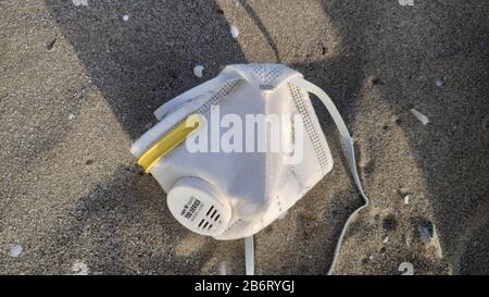 coronavirus, covid 19, sras cov 2, maladie chinoise mortelle a abandonné la protection de masque chirurgical d'une personne malade sur le sable de plage de drepanos grèce Banque D'Images