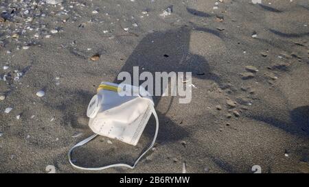 coronavirus, covid 19, sras cov 2, maladie chinoise mortelle a abandonné la protection de masque chirurgical d'une personne malade sur le sable de plage de drepanos grèce Banque D'Images