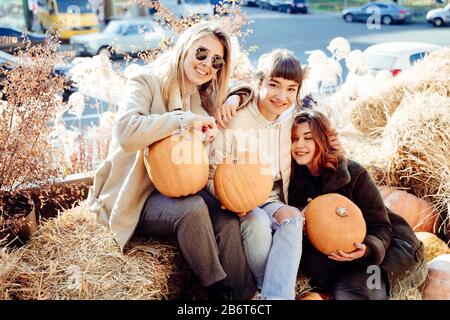 Les filles tient les citrouilles dans les mains sur le fond de la rue. Banque D'Images