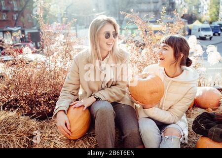 Les filles tient les citrouilles dans les mains sur le fond de la rue. Banque D'Images