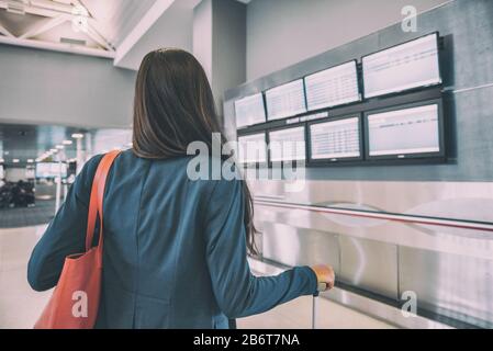 Voyage aéroport touristique femme attendant le retard de vol regarder les écrans du terminal de l'aéroport montrant des vols annulés, Corona virus COVID-19 concept. Annulation de vacances de l'industrie du tourisme. Banque D'Images