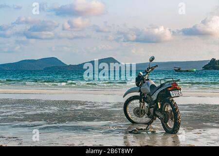 Une moto argentée se trouve sur la plage Banque D'Images