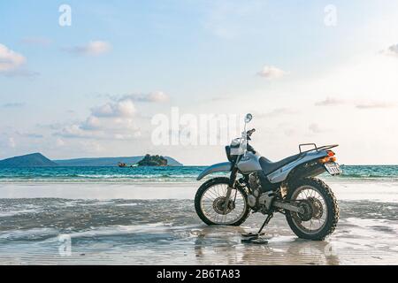 Une moto argentée se trouve sur la plage Banque D'Images