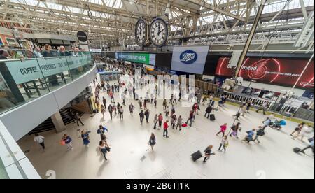 Les clients d'un café de la gare de Waterloo surplombent les voyageurs ferroviaires alors qu'ils se déplacent dans un flou vers et en train de suivre le hall principal à l'heure du déjeuner en semaine. Banque D'Images