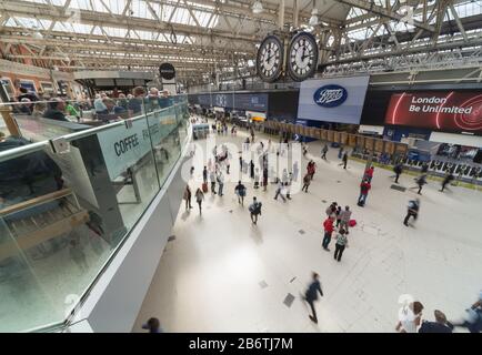 Les clients d'un café de la gare de Waterloo surplombent les voyageurs ferroviaires alors qu'ils se déplacent dans un flou vers et en train de suivre le hall principal à l'heure du déjeuner en semaine. Banque D'Images