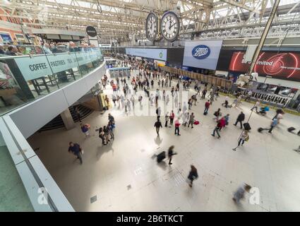 Les clients d'un café de la gare de Waterloo surplombent les voyageurs ferroviaires alors qu'ils se déplacent dans un flou vers et en train de suivre le hall principal à l'heure du déjeuner en semaine. Banque D'Images