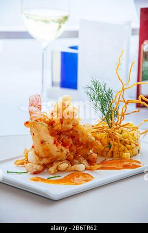 Crevettes tigrées épicées et frites croustillantes avec salsa à la mangue et sauce aux mille piments chauds sur la plaque blanche Banque D'Images