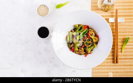 Mélanger les légumes frits avec les champignons, le paprika, les oignons rouges et le brocoli. Des aliments sains. Cuisine asiatique. Vue de dessus, en hauteur Banque D'Images