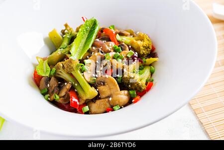 Mélanger les légumes frits avec les champignons, le paprika, les oignons rouges et le brocoli. Des aliments sains. Cuisine asiatique. Banque D'Images
