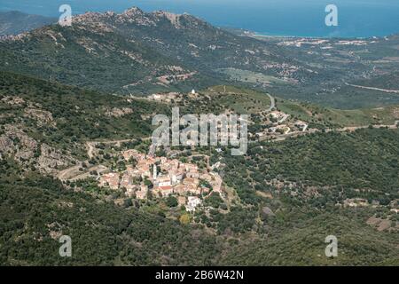 Ancien village de montagne de Palasca dans la région Balagne de Corse avec littoral et mer méditerranéenne au loin Banque D'Images