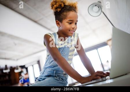 Jeu, étude, concept amusant. Des enfants heureux de passer du temps avec un ordinateur portable et la technologie moderne. Banque D'Images