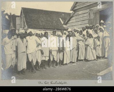 Un groupe de travailleurs contractuels de l'Inde britannique dans ce qu'on appelle "koelieDepot", le point central d'assemblage pour les immigrants à Paramaribo. Hindustani entre hommes et femmes est un officier de police ou un officier de police européen. Partie de l'album Souvenir de Voyage (partie 4), sur la vie de la famille Dooyer dans et autour de la plantation Ma Retraite au Suriname pendant les années 1906-1913. Fabricant : Photographe: Gomez Burke (éventuellement) Lieu de fabrication: Suriname Date: 1891 Caractéristiques physiques: Gélatine argent imprimé matériel: Papier technique: Gélatine argent imprimé dimensions: Photo: H 120 mm × W 170 mm Date: 1891- Banque D'Images