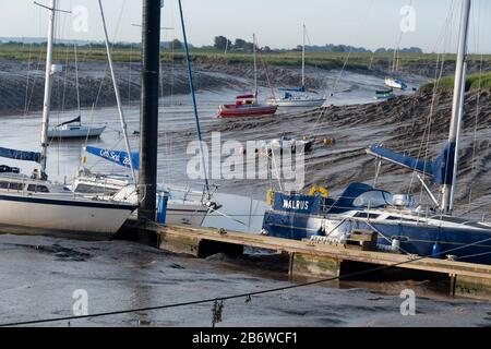 Des bateaux sont disponibles pour les amarres sur le lit de la rivière des marées, River Parrett, Burnham-on-Sea, Somerset, Angleterre Banque D'Images