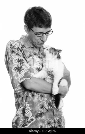 Studio shot of man holding et regardant Cute cat Banque D'Images